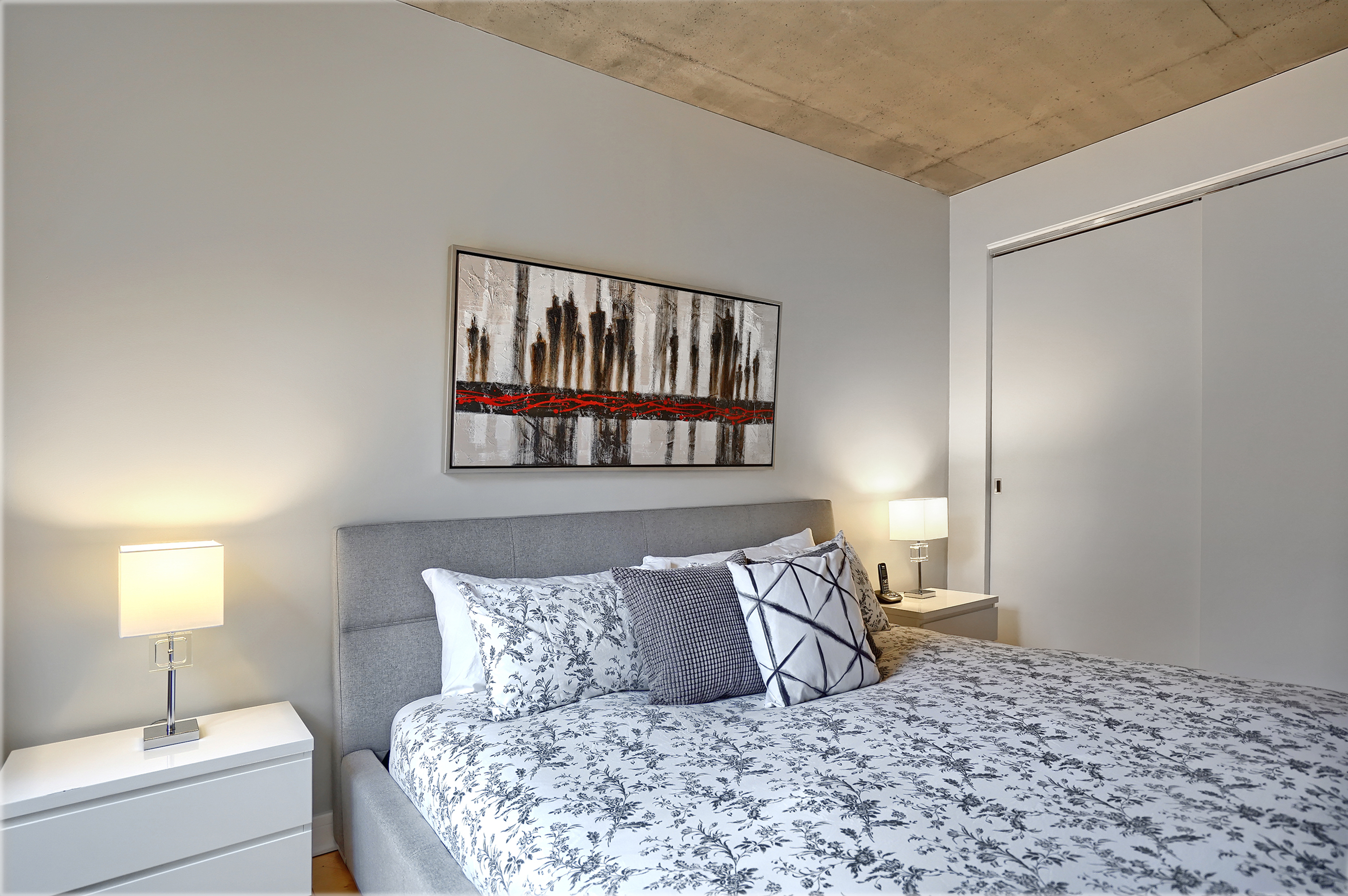 Close angled view of this King size bed with a memory foam mattress Tempur Pedic.  On the right we can see the large doors of the closet.  There is so much room for your clothes, luggage and shoes in this executive suite downtown Montreal