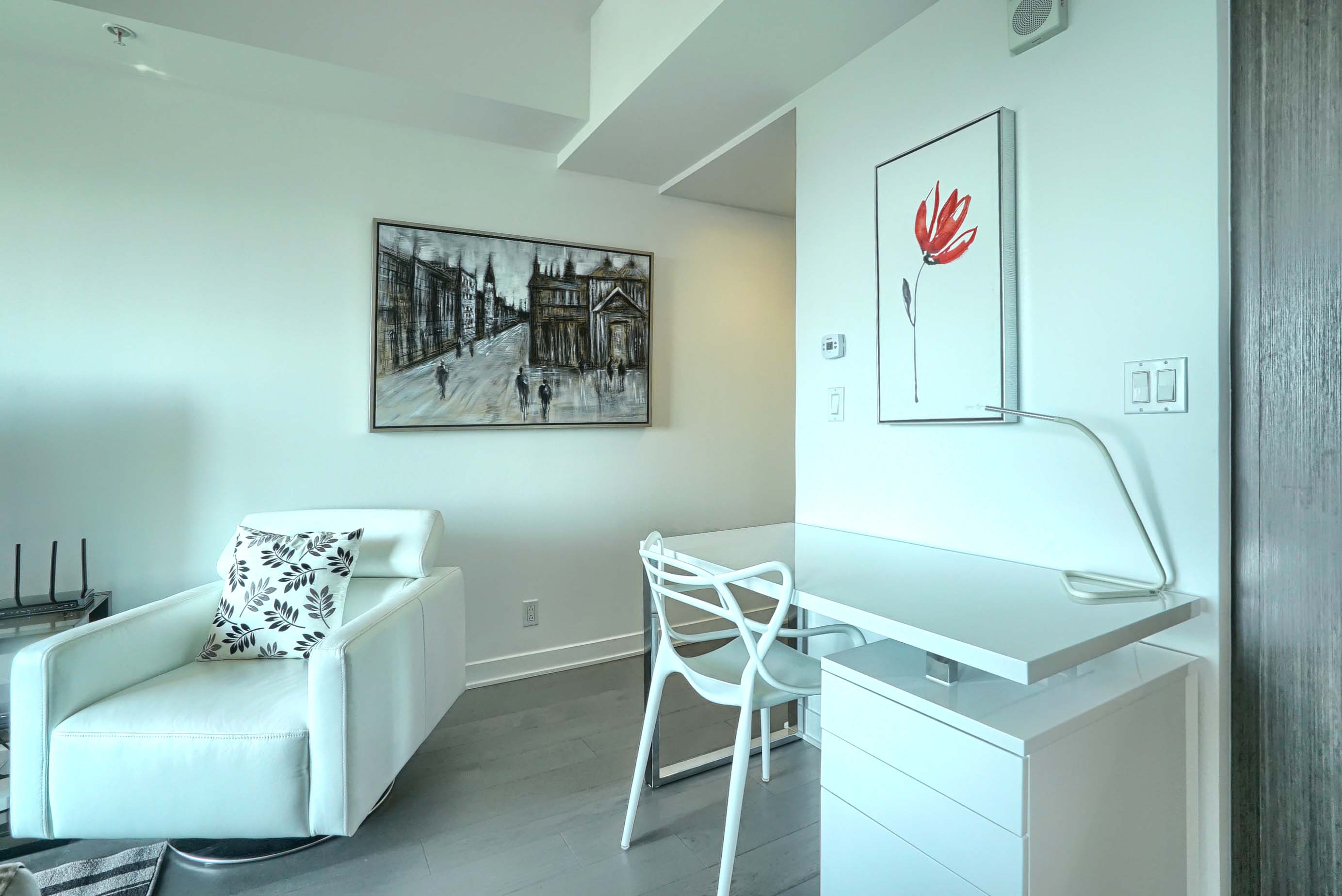 Gros plan du bureau et de la chaise ainsi que de la chaise surdimensionnée en cuir blanc moelleux dans cet hébergement corporatif à Montréal 