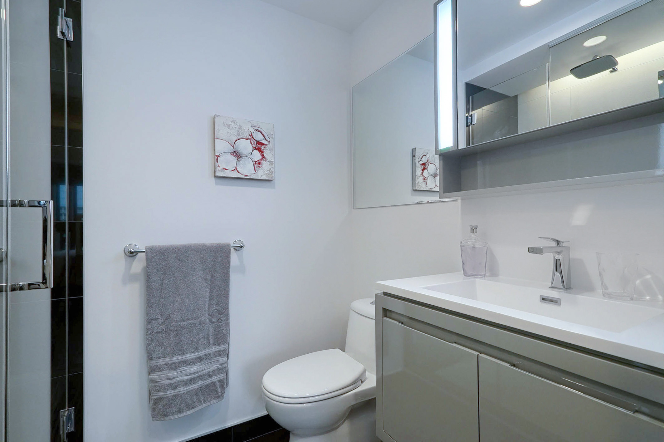 View of the bathroom showing the over-sized sink and toilet. Modern luxury in this furnished executive housing apartment in Montreal